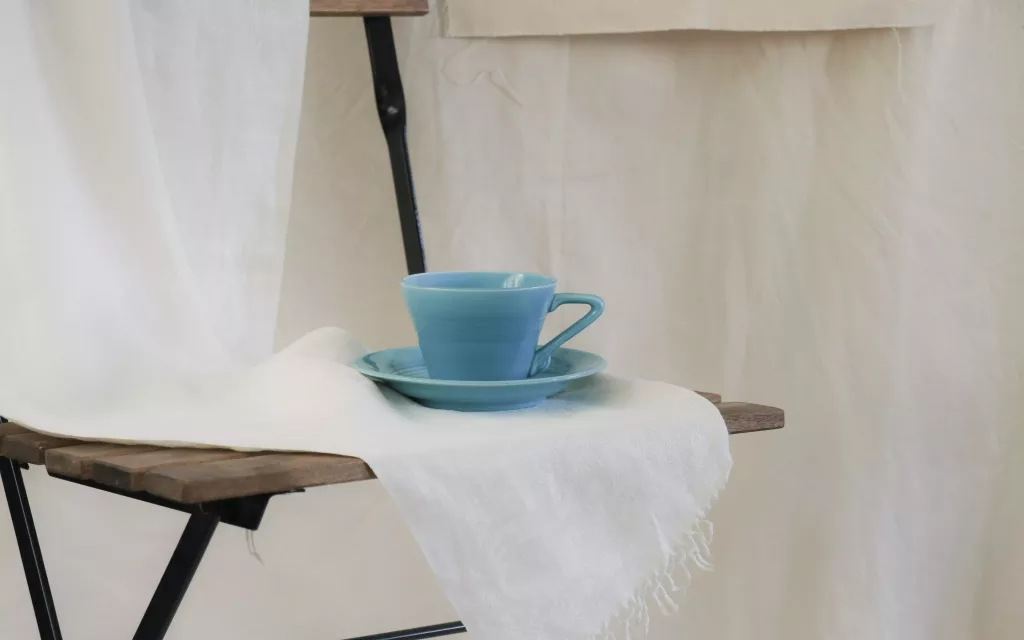 tasse à thé bleue sur nappe en lin blanche